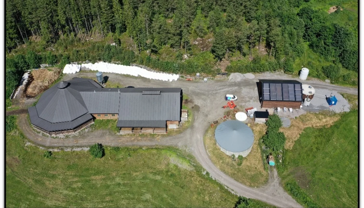 Kufjosen til venstre og forskningsreaktor for biogass til hoyre Kufjøsen til venstre og biogassreaktoren til høyre. Norsøk har operert en forskningsreaktor i over ti år. En ny og modernisert reaktor ble ferdigstilt i 2023. (Foto: Vegard Botterli)